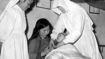 Two Sisters helping a mother with her baby in China